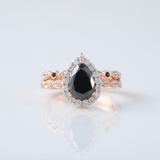 Discover the timeless elegance of our Vintage Pear Black Diamond Moissanite Engagement Ring Set, beautifully crafted in 14K Rose Gold. This exquisite ring set combines classic vintage charm with modern sophistication, featuring a stunning pear-shaped black diamond moissanite that dazzles with unique allure. Perfect for those who appreciate distinctive, handcrafted jewelry.