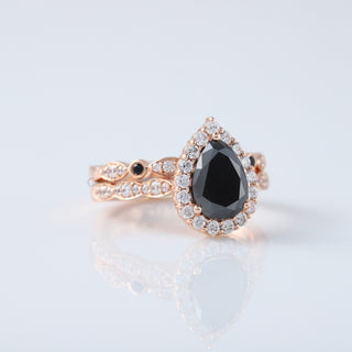 Discover the timeless elegance of our Vintage Pear Black Diamond Moissanite Engagement Ring Set, beautifully crafted in 14K Rose Gold. This exquisite ring set combines classic vintage charm with modern sophistication, featuring a stunning pear-shaped black diamond moissanite that dazzles with unique allure. Perfect for those who appreciate distinctive, handcrafted jewelry.