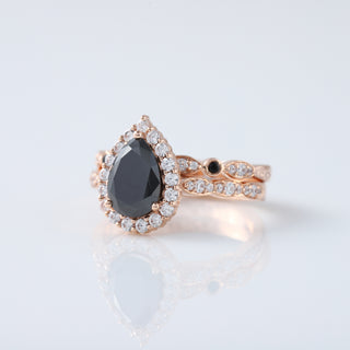 Discover the timeless elegance of our Vintage Pear Black Diamond Moissanite Engagement Ring Set, beautifully crafted in 14K Rose Gold. This exquisite ring set combines classic vintage charm with modern sophistication, featuring a stunning pear-shaped black diamond moissanite that dazzles with unique allure. Perfect for those who appreciate distinctive, handcrafted jewelry.